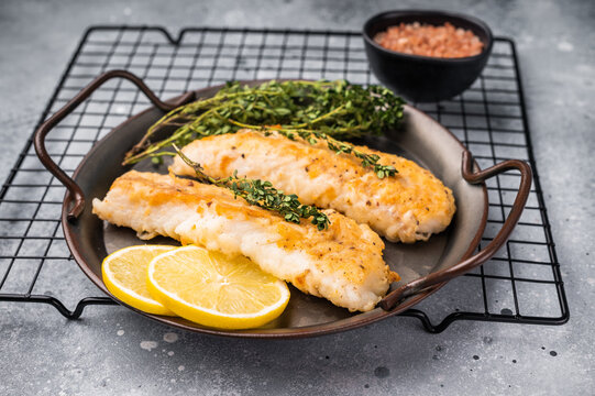 Baked Cod fish fiilet, fried whitefish meat. Grey background. top view