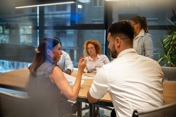 Business colleagues engaged in serious team discussion at modern office meeting