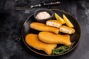Crispy fried cod Fish sticks on plate. black background. top view
