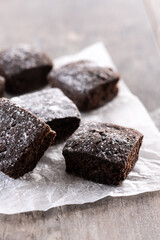 Homemade chocolate brownies with sugar powder on wooden table