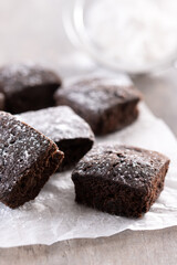 Homemade chocolate brownies with sugar powder on wooden table