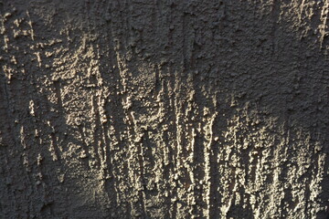Fototapeta premium Construction materials, materials for finishing walls. Bark beetle, shirpa sand on a wall painted with brownish-gray paint, reliefs, recesses, bulges.