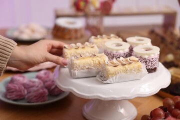Guest taking delicious dessert from buffet table, closeup