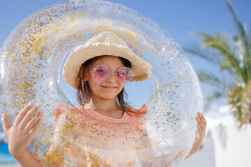 Funny little girl relaxing on summer vacation. The child has fun on the beach. Cute baby in a...