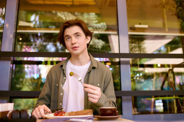 Young man enjoys a delicious meal in a modern cafe setting