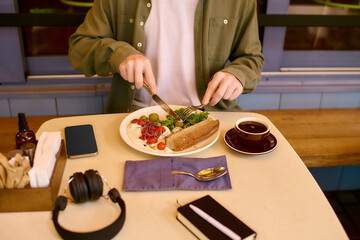 Young man enjoys a meal in a modern cafe with a stylish atmosphere and delicious food