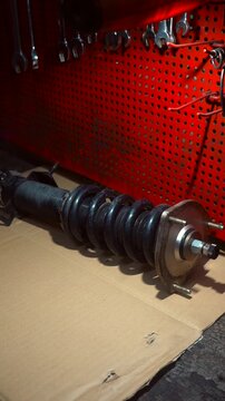 A pre-assembled car shock absorber with a spring for installation on a vehicle. Car suspension. Shock absorber. Spring.