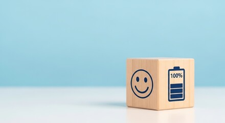 Mental Health in the workplace, A wooden block features a smiling face and a fully charged battery icon against a light blue background, positivity and energy.