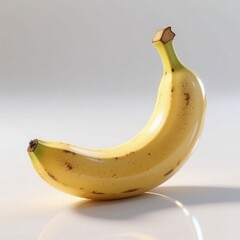 A single, ripe banana with a glossy peel and brown spots, isolated on a clean white background