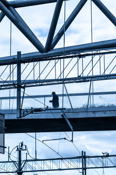 Person walking on suspended pedestrian bridge between buildings showing urban dynamics contemporary architecture and active lifestyle under soft daylight in Oslo city
