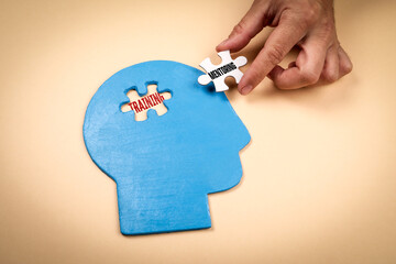 Concept of training and mentoring represented by puzzle pieces fitting into a blue human head shape on beige background symbolizing learning and personal development