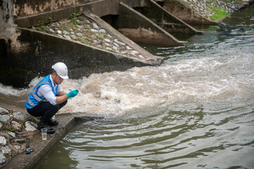 Wastewater treatment worker is collecting samples of water from a public well
