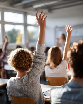 Students actively participate by raising hands in a bright sunlit classroom during a lesson