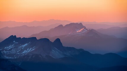 Dramatic Sunset Over Snow-Capped Mountain Peaks with Misty Layered Ranges