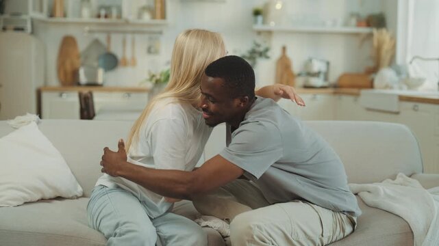 Cute young man and woman making peace after quarrel, diverse people communicate. Blonde swedish lady and african american guy hugging tenderly, good relationship and marriage, happy interracial pair