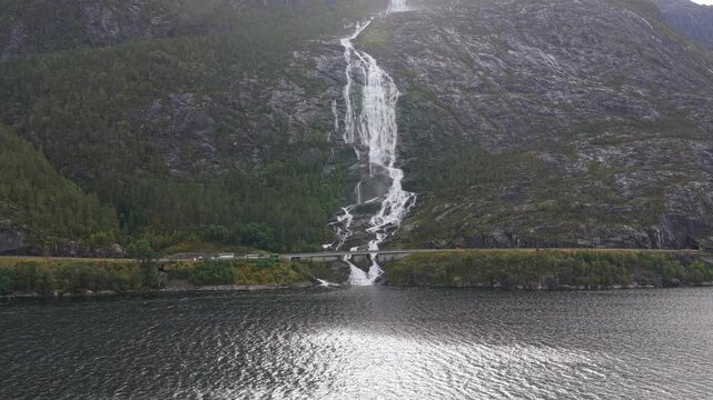 Aerial view of iconic Langfossen waterfall flowing in Norway fjord