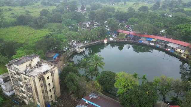 ariel view of small pond with temple half circle shot of small village