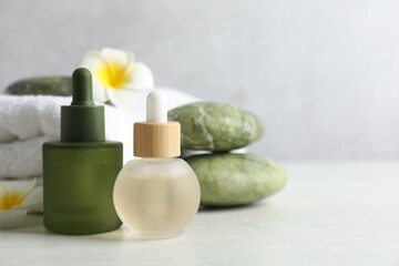 Beautiful spa composition with essential oils on light table, closeup. Space for text