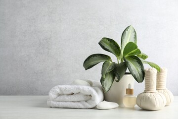 Beautiful spa composition with herbal bags and essential oil on table against light gray background. Space for text
