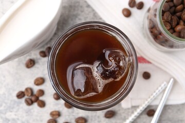 Tasty iced coffee, beans and milk on light table, flat lay