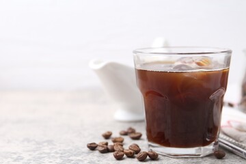 Tasty iced coffee and beans on light table, closeup. Space for text