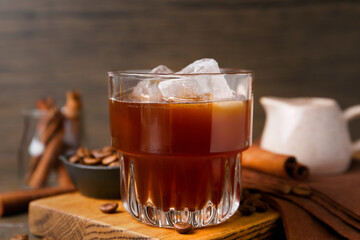 Tasty iced coffee and beans on wooden table, closeup