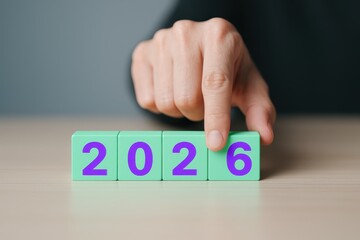 Hand Arranging 2026 Date on Green Blocks