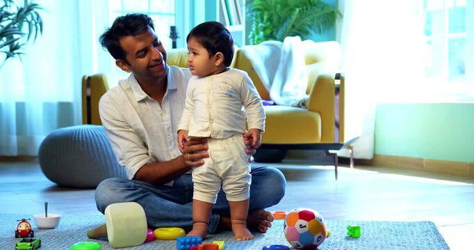 Indian infant baby balancing standing for the first time while father happy witnessing this precious lifetime milestone, filled with love, bonding, joy, and emotional parenting moments in modern home