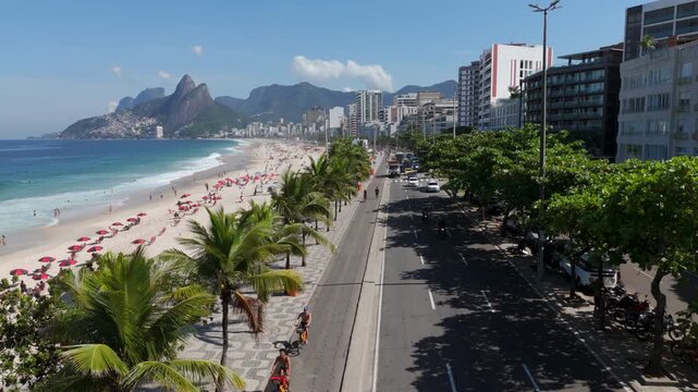 Aerial view of famous Ipanema Beach, lined with palm trees on a bright, sunny day in Rio de Janeiro, Brazil.