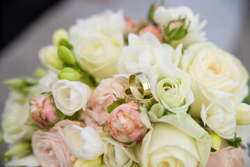 wedding bouquet of pink roses combined with golden rings