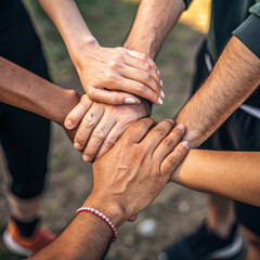 Teamwork concept shown by diverse hands stacked together symbolizing unity support and collaboration in outdoor setting with natural light