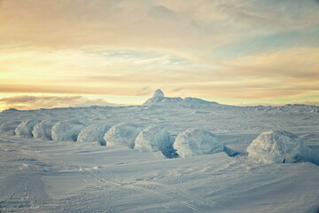 Sculpted Snowdrifts and Summit of Halti Mountain at Sunset