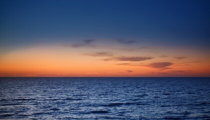 Obraz premium Dark Ocean Horizon With A Gradient Sky Transitioning From Blue To Orange