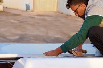 renewable energy. sustainable living. man maintaining the solar panels on his motorhome