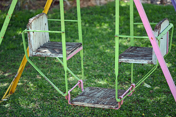 Old baby swing in the shade.