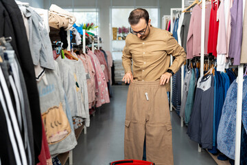 European man trying on pants in clothing store