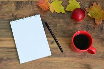 Cozy Autumn Desk Scene with empty Notebook and a red mug of Coffee