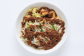Top view of a hearty plate of Toge Goreng, bean sprouts with noodles and tofu drenched in a rich,...