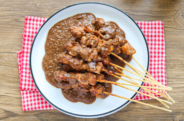 Top view of authentic chicken satay smothered in a thick, rich, and flavorful peanut sauce.
