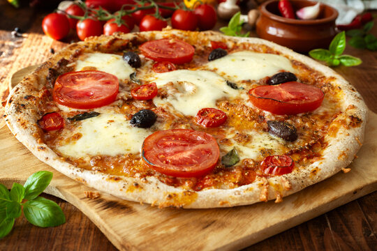 Fresh Homemade Pizza Margherita with tomatoes, olives, Mozzarella, and garlic.
