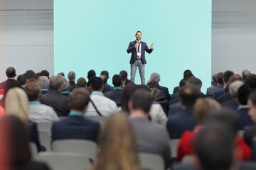 Man holding a microphone and talking on stage