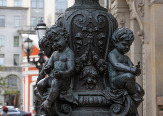 Fototapeta premium Antique cast iron black lamppost with small cherub decorations