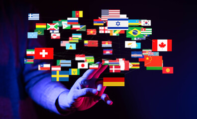 A hand reaching out towards a collection of global flags, illustrating concepts like connection,...