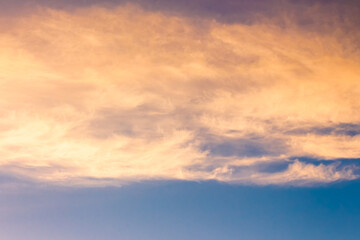 orange cloud on blue sky at sunset. beautiful nature background at dusk for meteorology. cloudscape in yellow light. abstract scene of summer weather