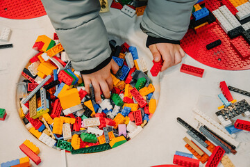 Obraz premium Prague, Czechia - September 20, 2025: Child hand playing with colorful Lego bricks