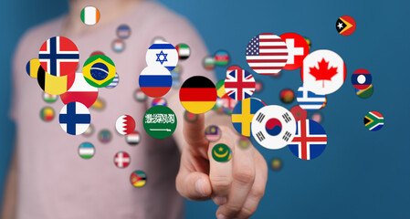 A person's finger touching various national flags symbolizing international relations, global...