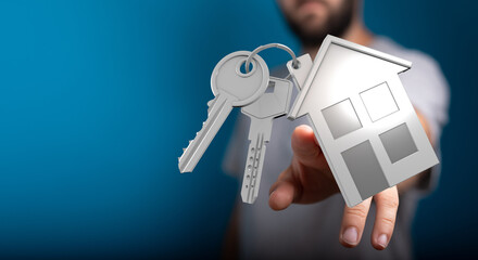 Conceptual image of a hand holding keys and a house silhouette, representing home ownership, real estate, and the feeling of security and belong