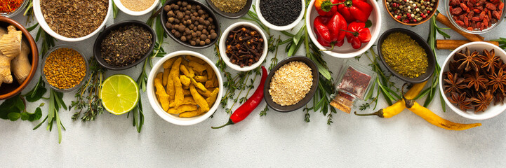 A vibrant assortment of spices and herbs on a gray background, offering a flavorful addition to any recipe, top view and copy space, banner
