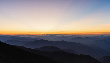 Fototapeta premium Sunrise over mountainous landscape with layers of hills and valleys 