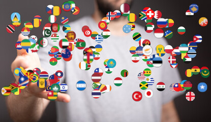 A hand reaching out to a cluster of flags, symbolizing global collaboration, interconnectedness,...